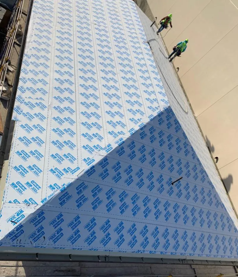 Professional roofers installing underlayment on a metal roof in Laconia